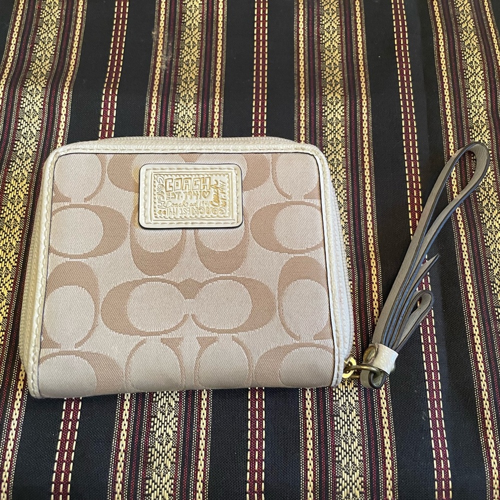 Coach cream wallet with pink inside.